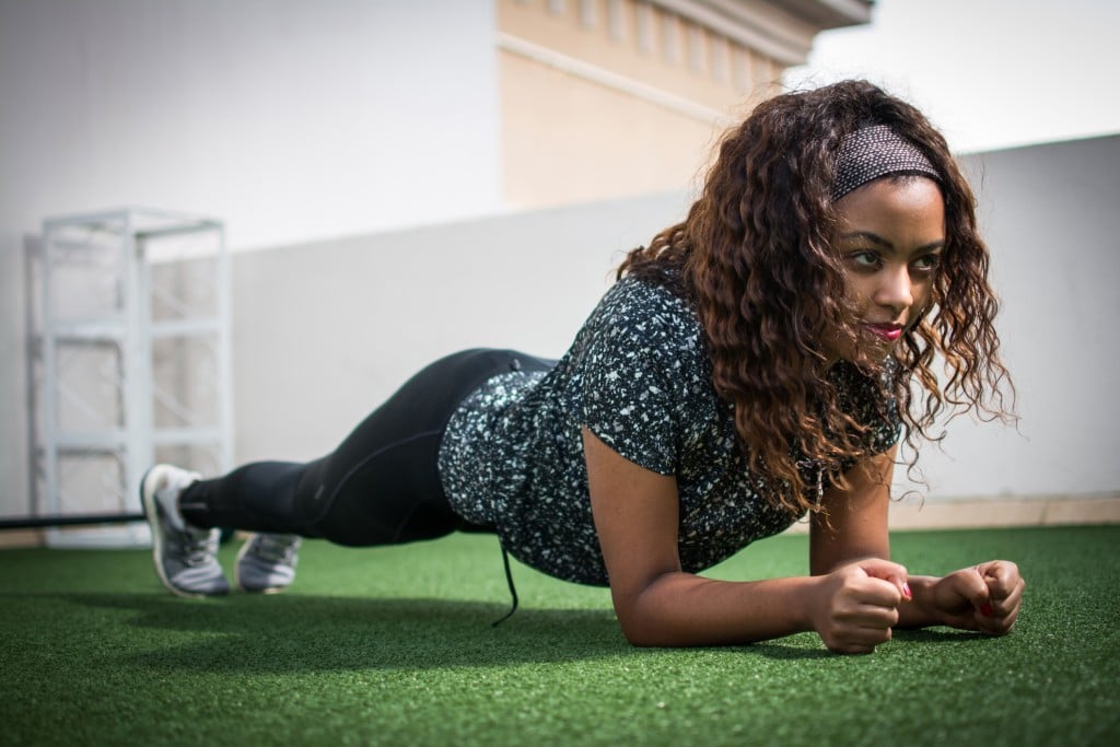 Beautiful African American Woman In Sports Clothing Demonstrating Plank Exercise For Abdominal Strength.