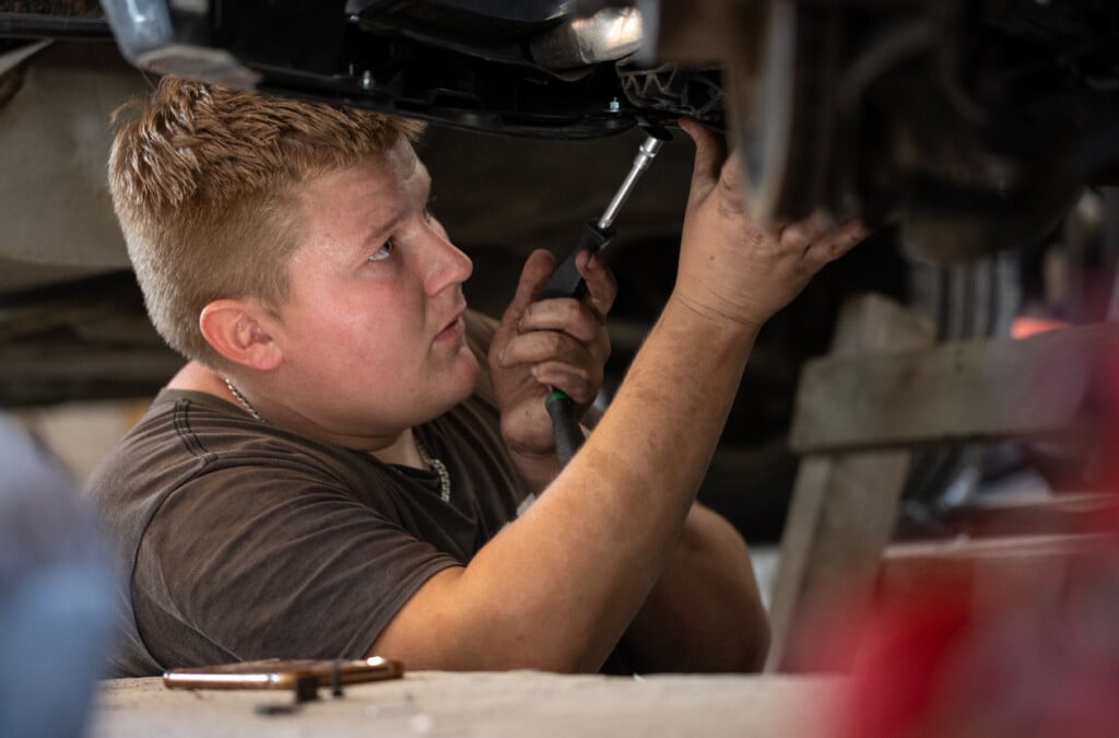 Young Auto Mechanic Repairs A Broken Car In A Car Repair Shop.