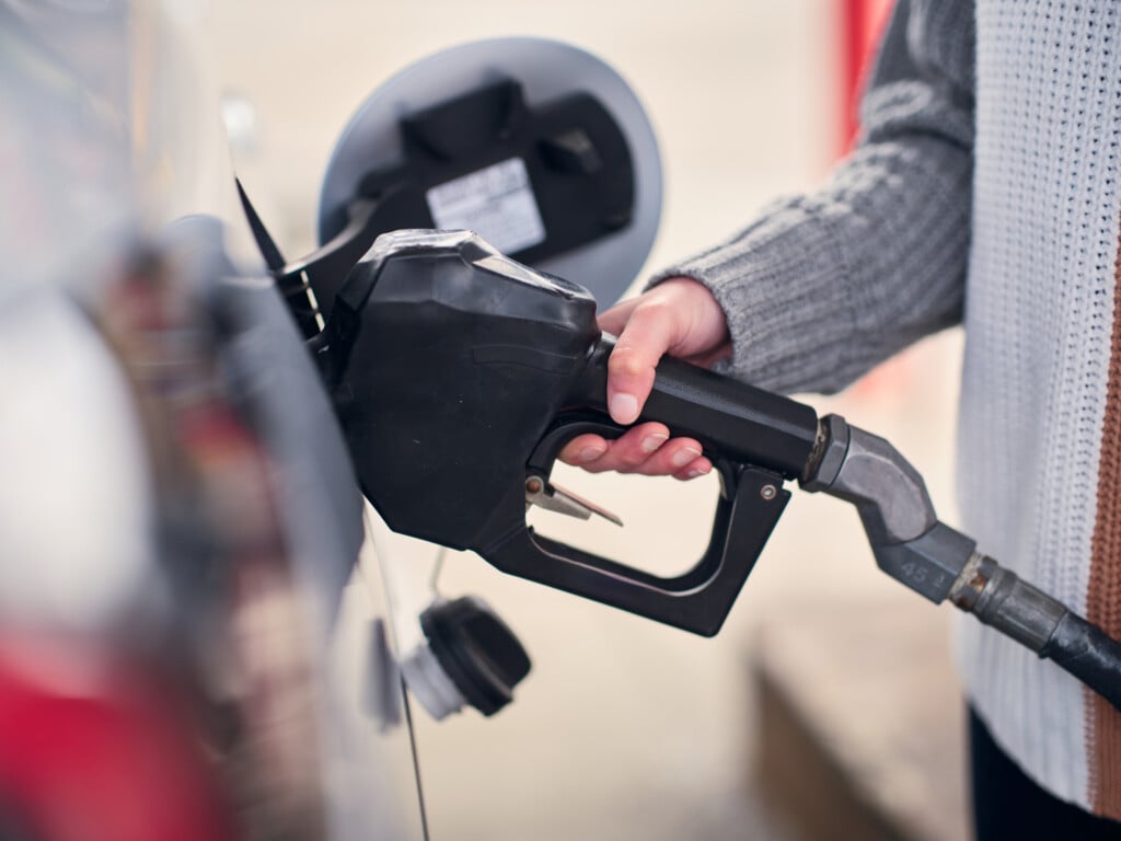 Young Woman Fueling A Car At A Convienence Store