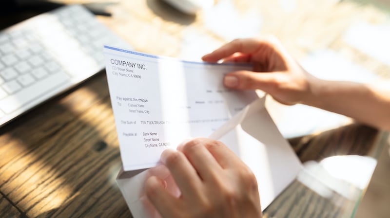 Businessperson Opening Envelope With Paycheck