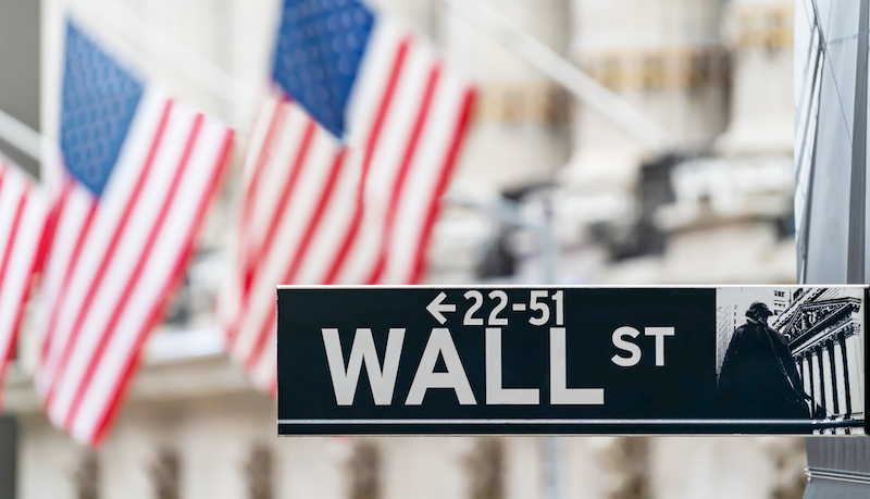 Wall Street Sign In New York City Financial Economy And Business District With America National Flag Background. Stock Market Trade And Exchange Zone.
