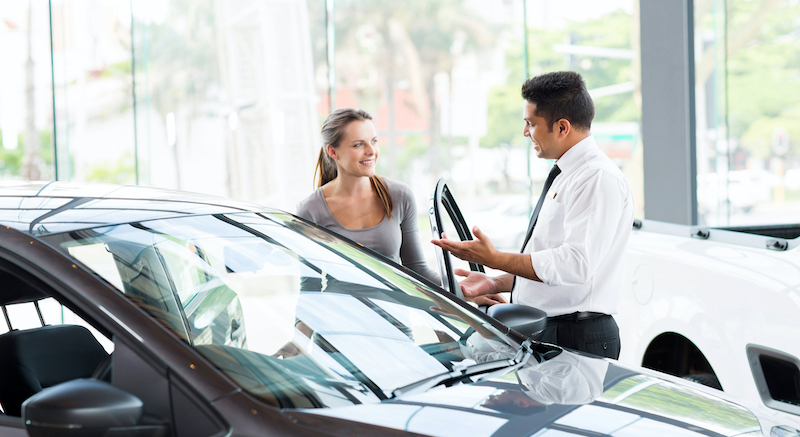 Vehicle Dealer Showing Young Woman New Car