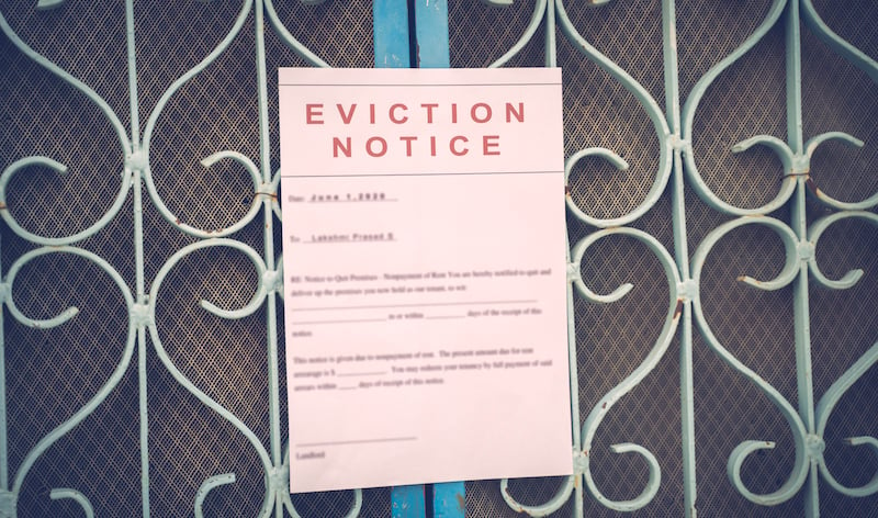 Foreclosed Or Eviciton Notice On A Main Door With Blurred Details Of A House With Vintage Filter.