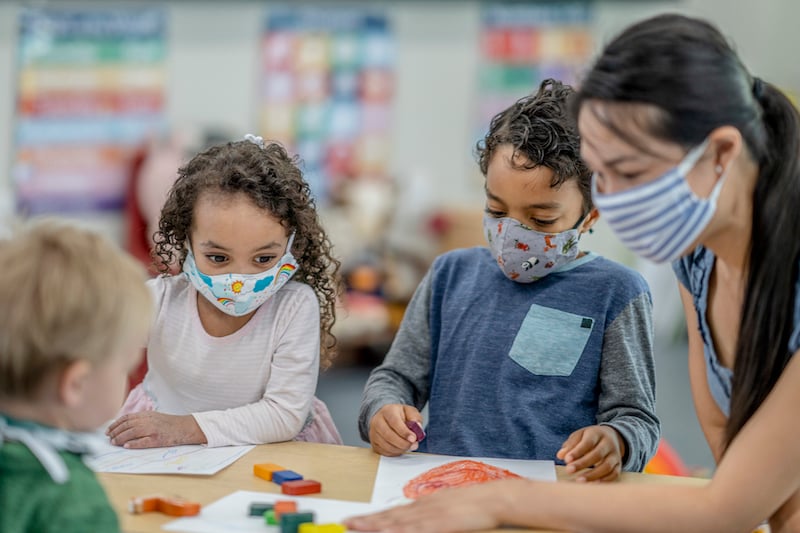 Group Of Children Colouring While Wearing Masks