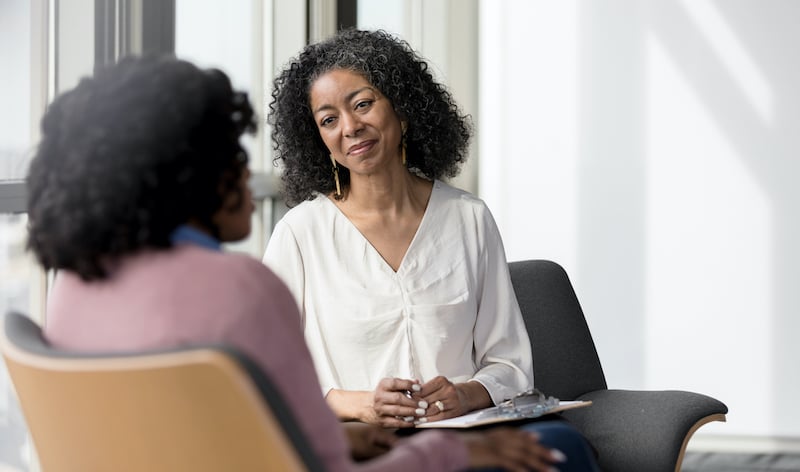 Mature Counselor Listens Compassionately To Unrecognizable Female Client