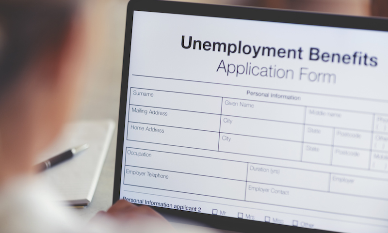 Woman Filling Out An Online Unemployment Benefits Application Form.