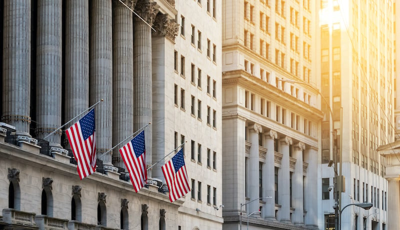 American Flags Flying In Front Of The Historic Buildings Of Wall Street In The Financial District Of New York City