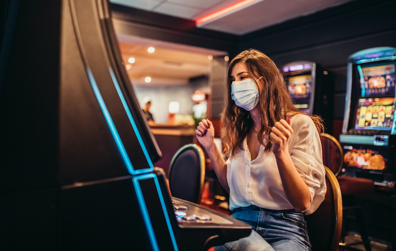 Woman Playing Slot Machine In Casino