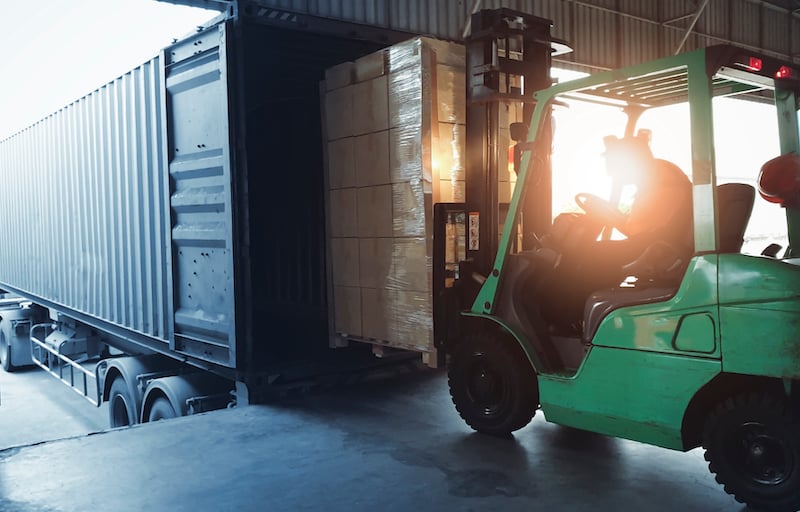 Forklift Loading Shipment Goods Pallet Into Container Shipping Truck. Cargo Freight, Logistics And Transportation.