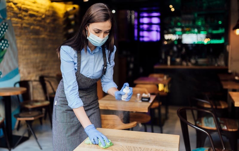 Young Caucasian Female Waitress Cleaning The Tables