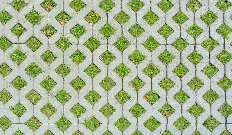 Geometric Background Of Eco Floor Bricks And Green Grass. Eco Parking Texture