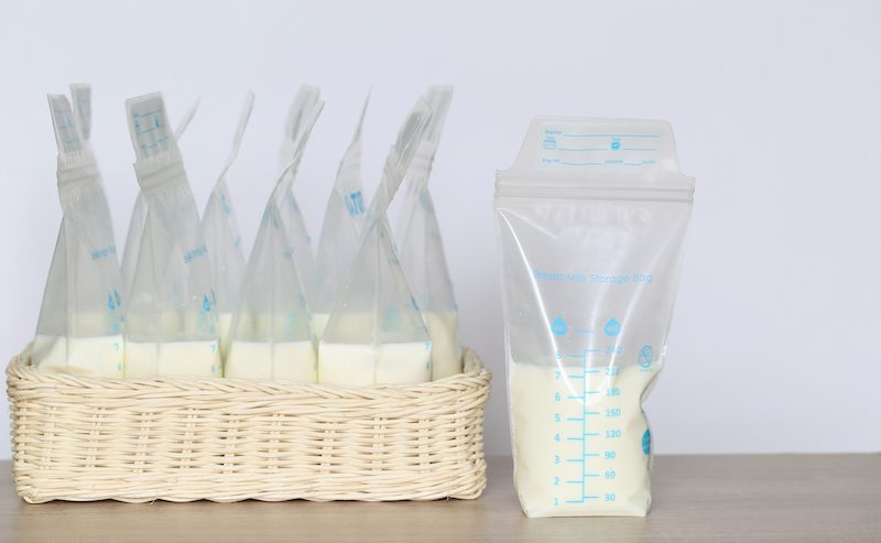 Frozen Breast Milk Storage Bags For New Baby On Wooden Table