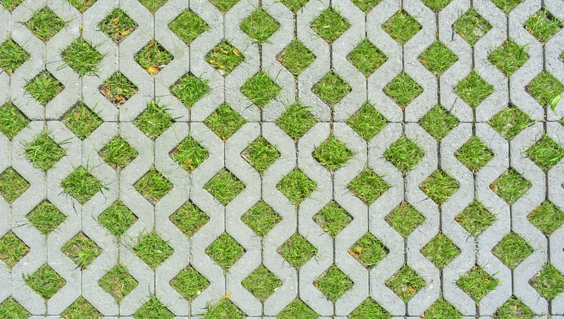 Geometric Background Of Eco Floor Bricks And Green Grass. Eco Parking Texture