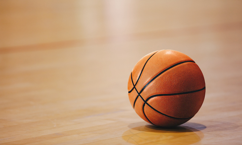 Orange Basketball Ball On Wooden Parquet. Close Up Image Of Basketball Ball Over Floor In The Gym