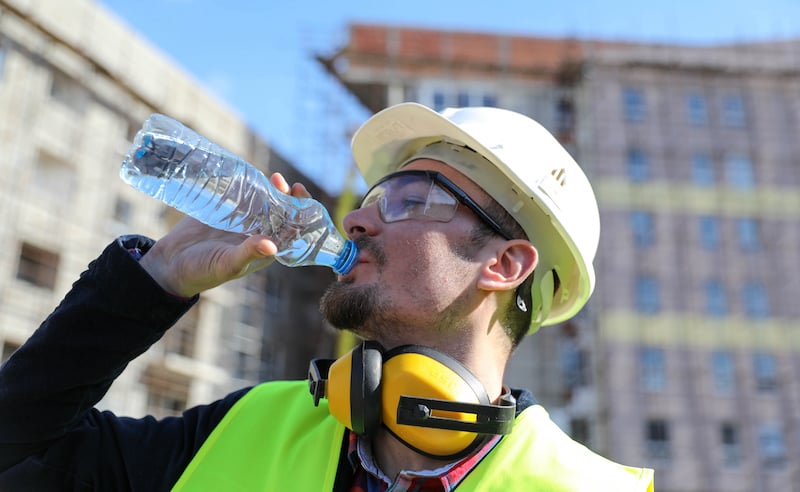 Boss At Construction Site With Bottle Of Water, Close Up