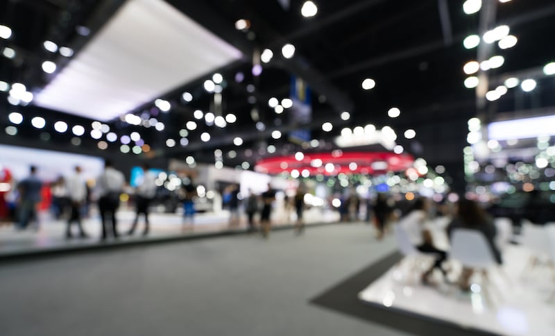 Blurred, Defocused Background Of Public Event Exhibition Hall. Business Trade Show Or Commercial Activity Concept