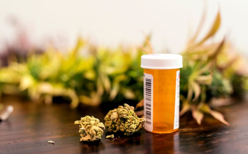 Marijuana Buds Sitting Next To Prescription Medicine Bottle