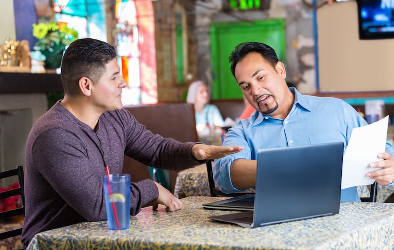 Hispanic Brothers Having Business Meeting In Family Owned Restaurant