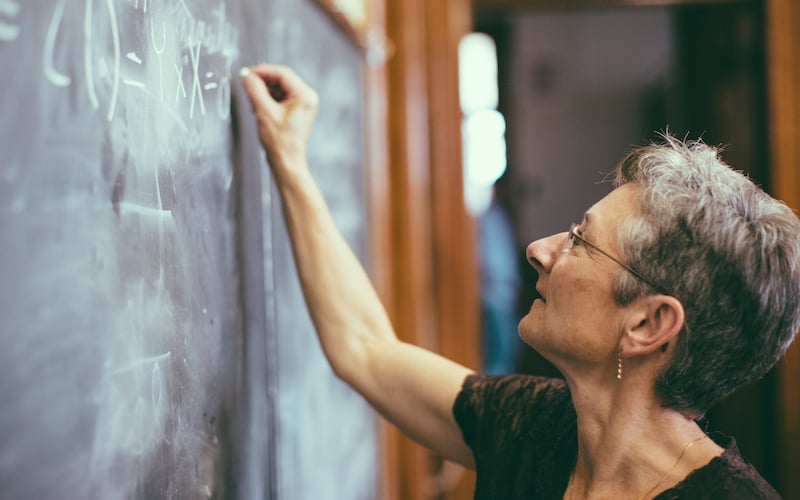 Mathemathics Professor At Chalkboard Writing Formula