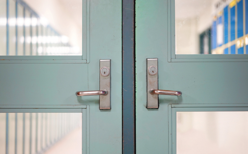 School Closed Due To Coronavirus. School Closure Under Covid 19 Global Pandemic. Selective Focus On Door And Handle With Blurred Hallway, Locker Background. Fight Against Public Health Risk Disease.
