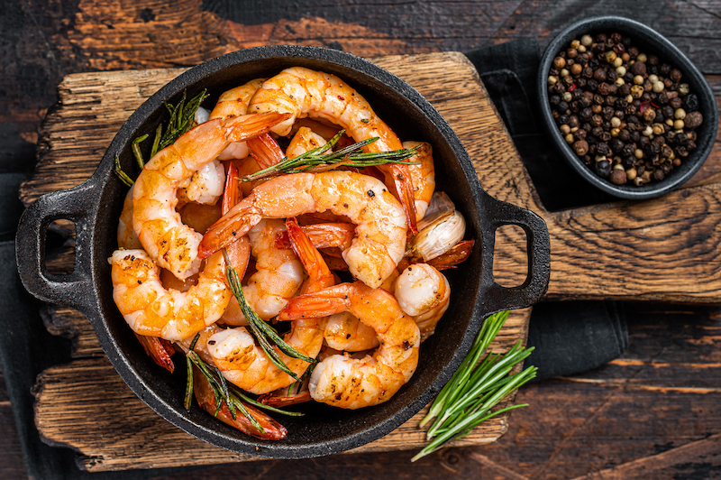 Roast Prawns Shrimps In A Pan With Herbs And Garlic. Dark Wooden Background. Top View