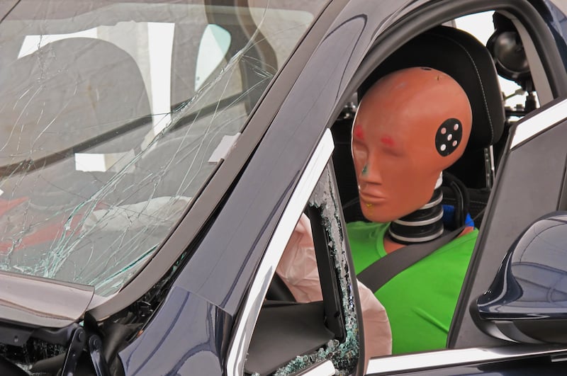 Driver's Side View Of A Car With A Crash Dummy At The Wheel