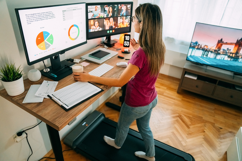 Woman At Standing Desk Home Office Talking On Business Video Call
