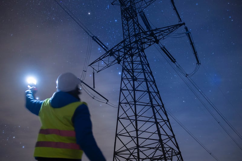 High Voltage Engineer Working At Night On The Field. Sustainable Energy.