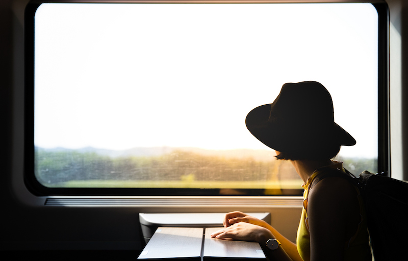 Young Pretty Woman Traveling Alone By Train Looking At The View Through The Window.