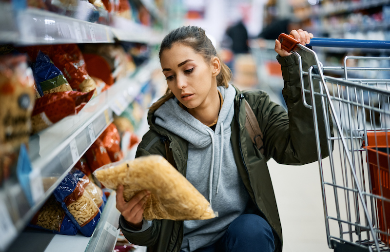 Young Woman Buying Pasta In Supermarket.
