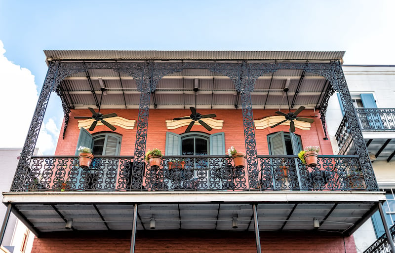 New Orleans, Usa French Quarter With Wrought Cast Iron Balcony Of Building In Traditional Architecture With Potted Plants Decoration In Louisiana Famous City