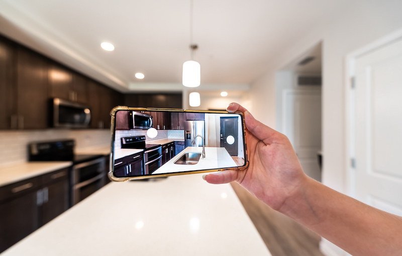Hand Photographing House Apartment Kitchen Island Room For Sale Or Rent With Phone Smartphone Closeup Point Of View In Modern Luxury Condo Home Tour With Blurry Bokeh Background