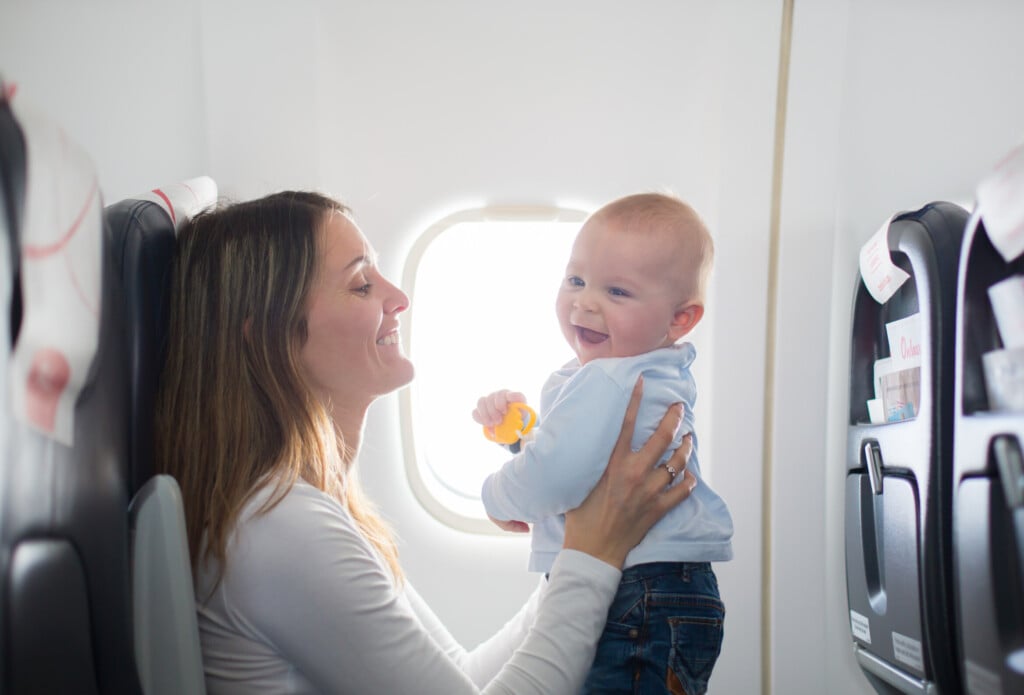 Young,mom,,playing,and,breastfeeding,her,toddler,boy,on,board
