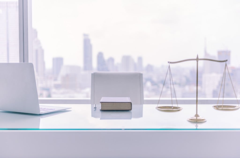 Law,books,computer,and,scales,of,justice,on,desk,in,lawyer