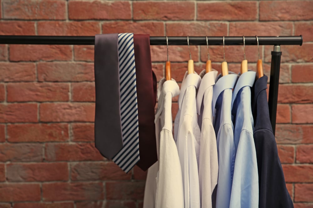 Hangers,with,male,shirts,and,ties,on,clothes,rail,against