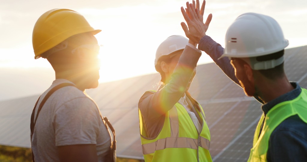 Happy,employees,of,solar,power,plant,raise,their,hands