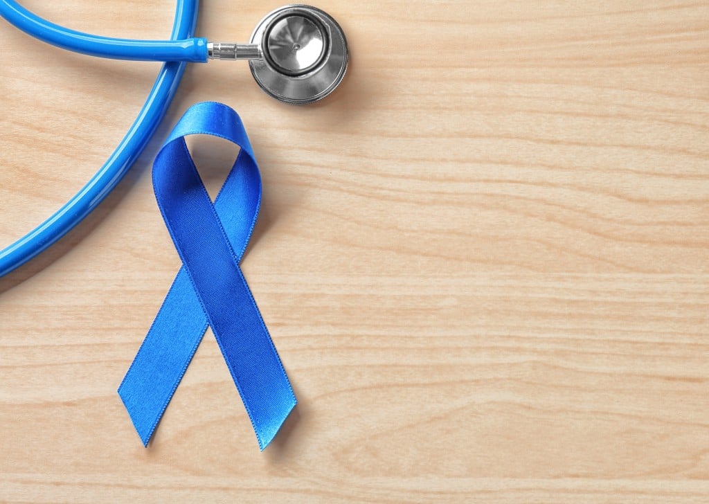 Blue,ribbon,and,stethoscope,on,wooden,background.,cancer,awareness,concept