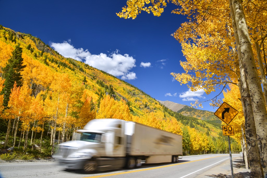 Tractor,trailer,truck,driving,along,colorado,highway,on,colorful,autumn