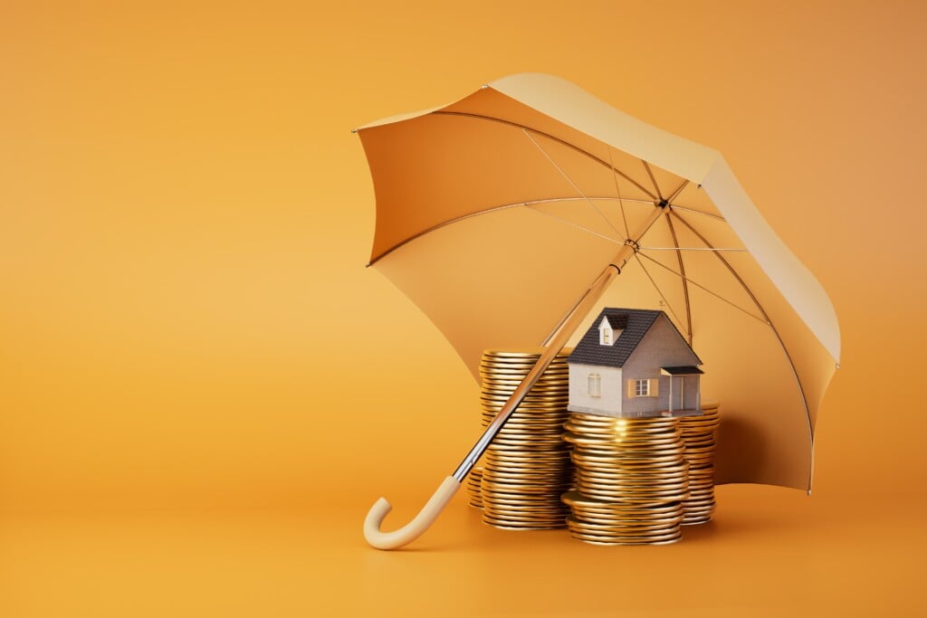Real estate investment risks:coins and a house under an umbrella on an orange background. 3D render.