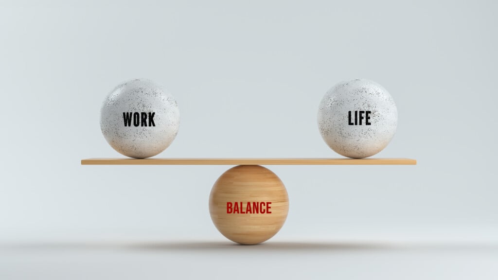 Wooden Balls Forming A Scale For Work, Life And Balance On White