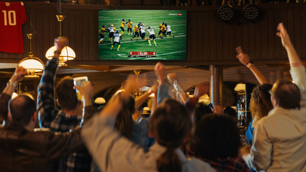 Football season alcohol safety: Group Of American Football Fans Watching A Live Match Broadcast