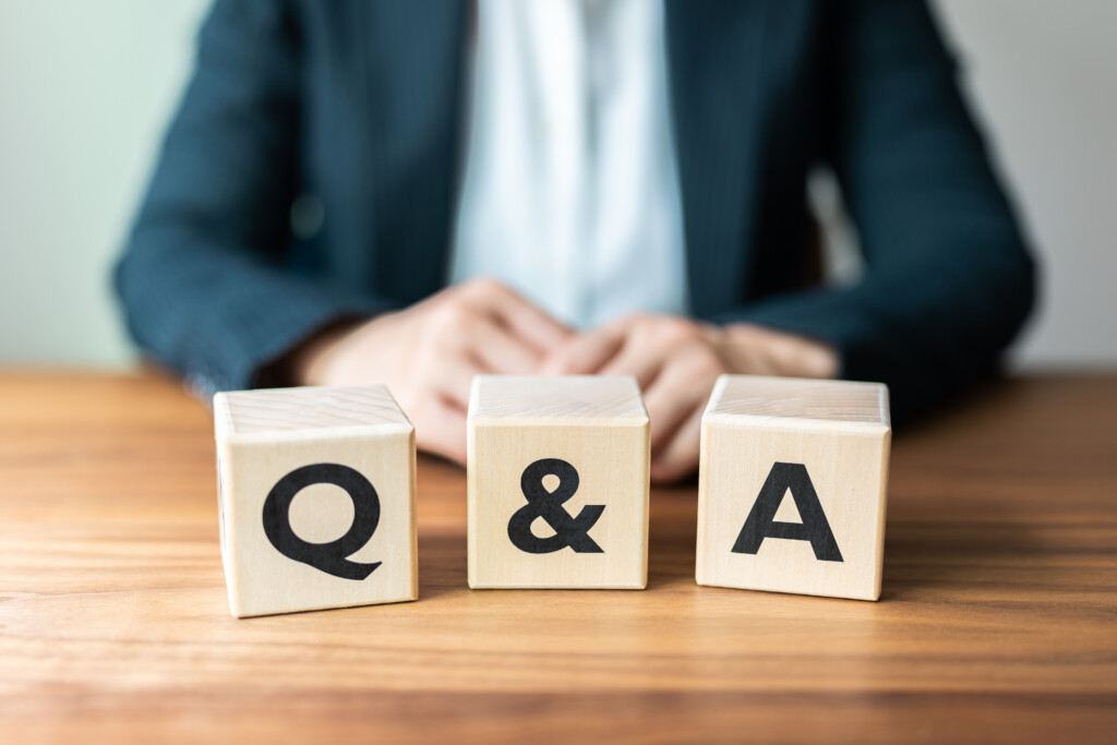 Q&A blocks sitting on a table with man dressed in a suit behind them