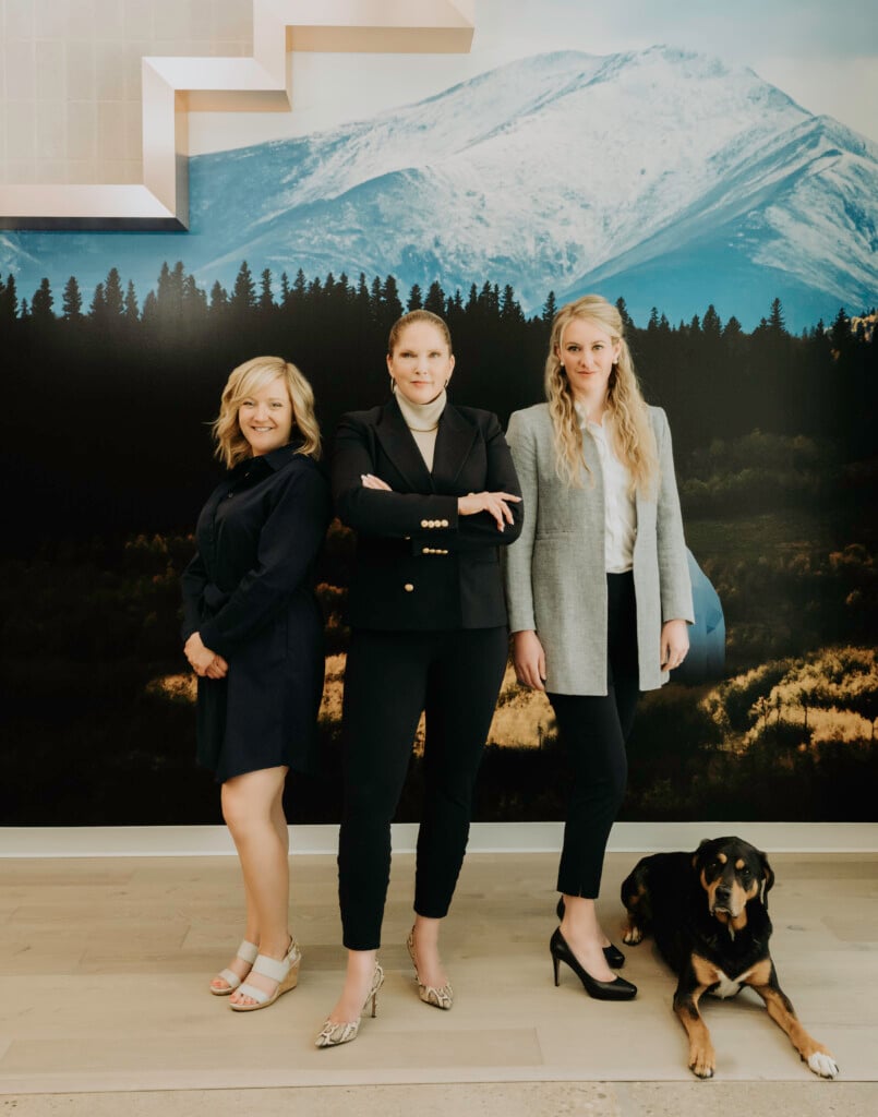 The Women of Wells Family Law: 3 women standing in the office with a dog.