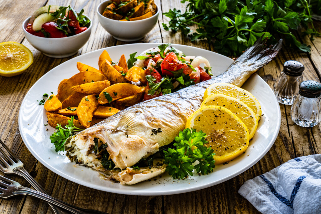 Fish Dish Roasted Sea Bream With Vegetables On Wooden Table