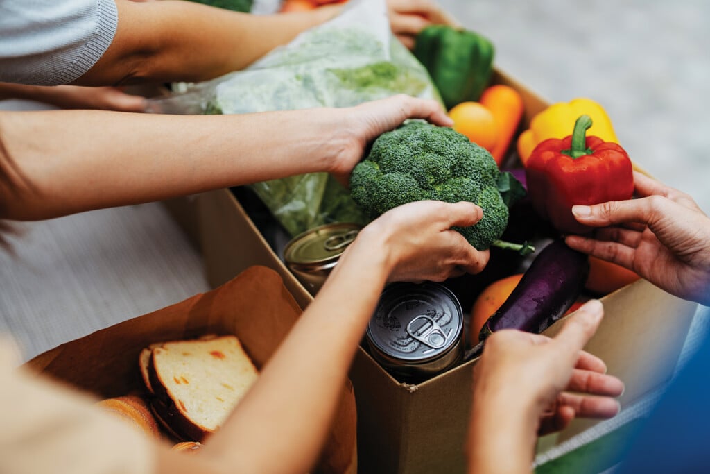 Asian Volunteers Packing Donated Goods And Groceries At Food Bank