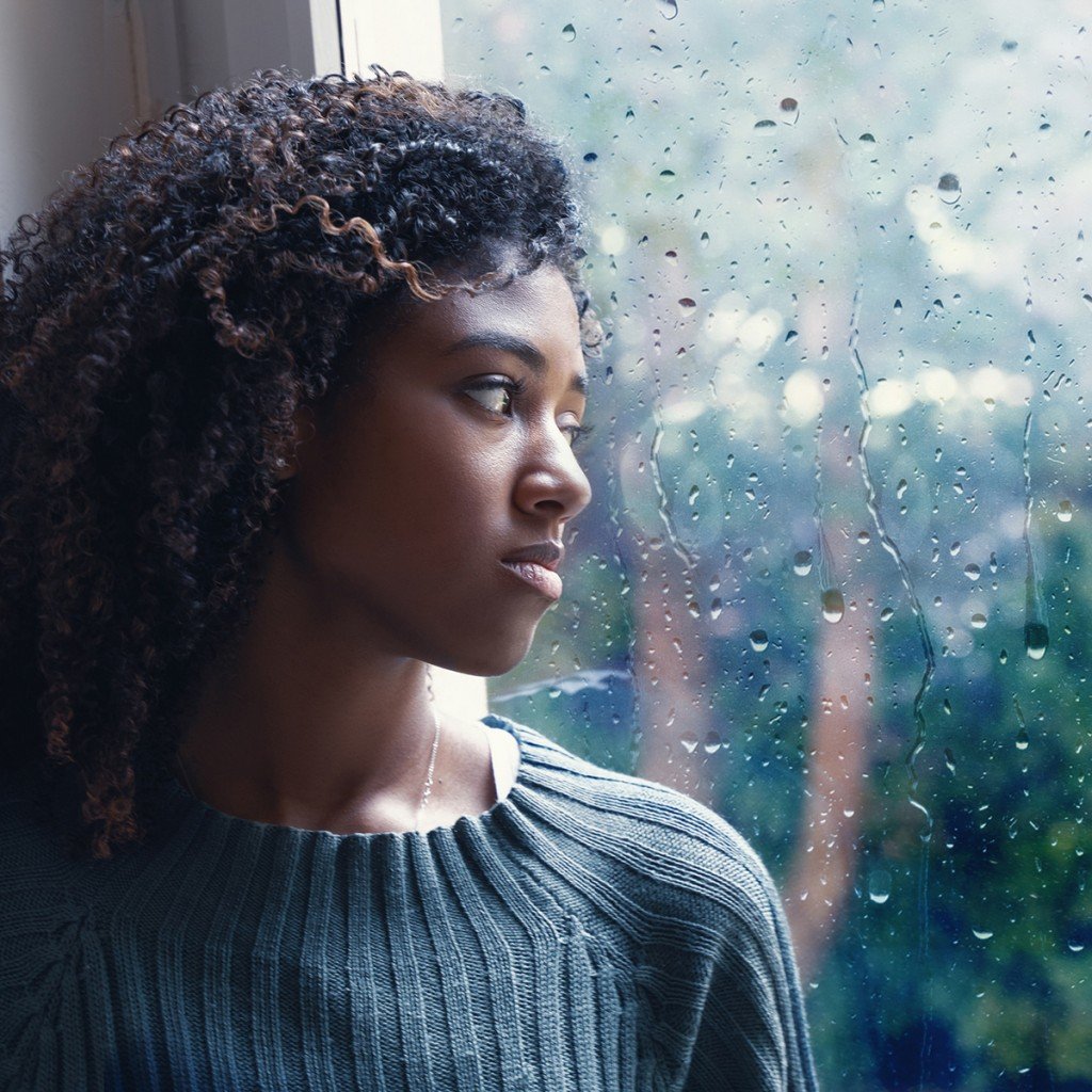 Young Worried Woman Looking Out Of The Window