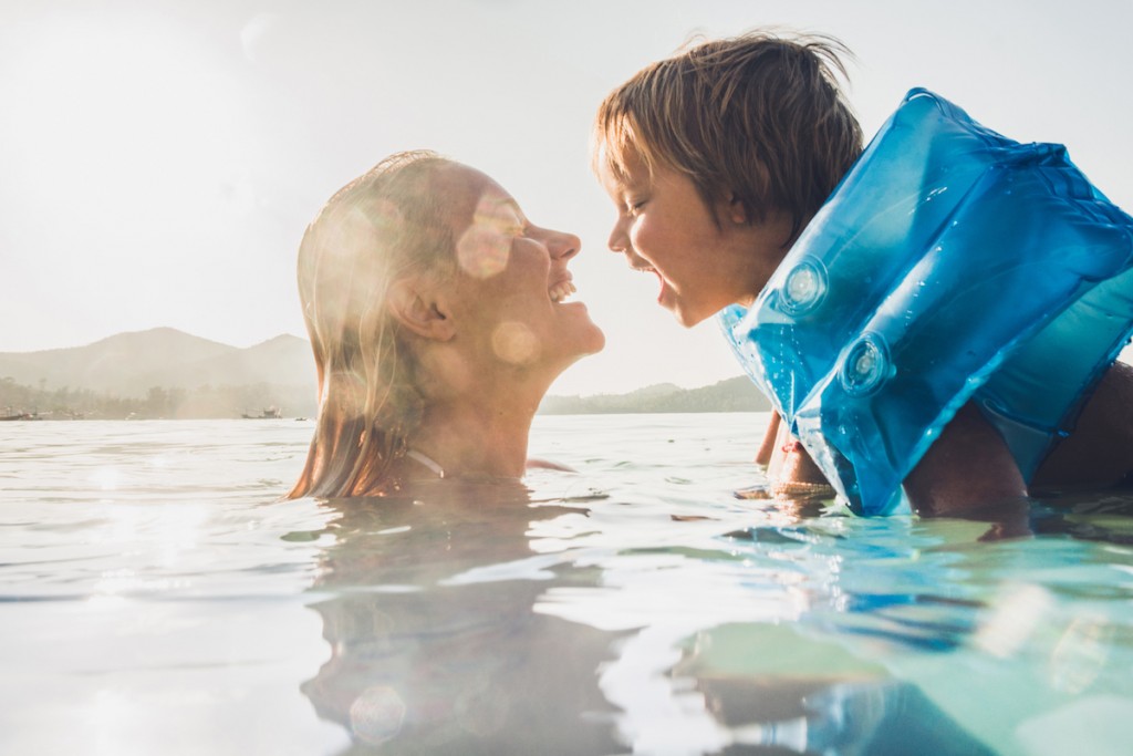 Happy Mother And Son Having Fun While Swimming In Sea On Summer Vacation.