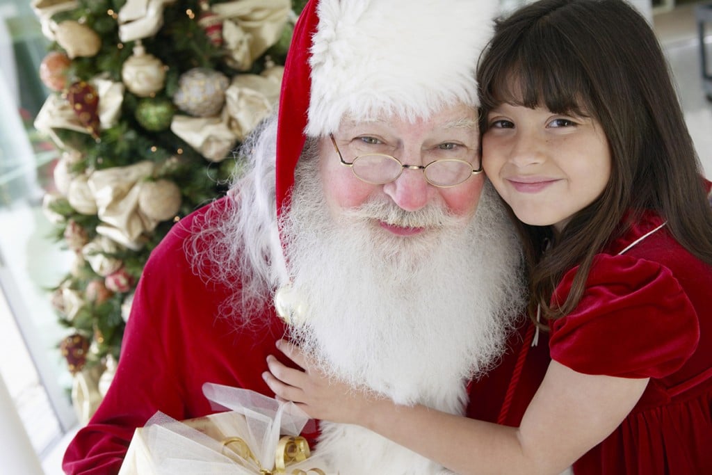 Portrait Of A Young Girl With Her Arm Around Father Christmas