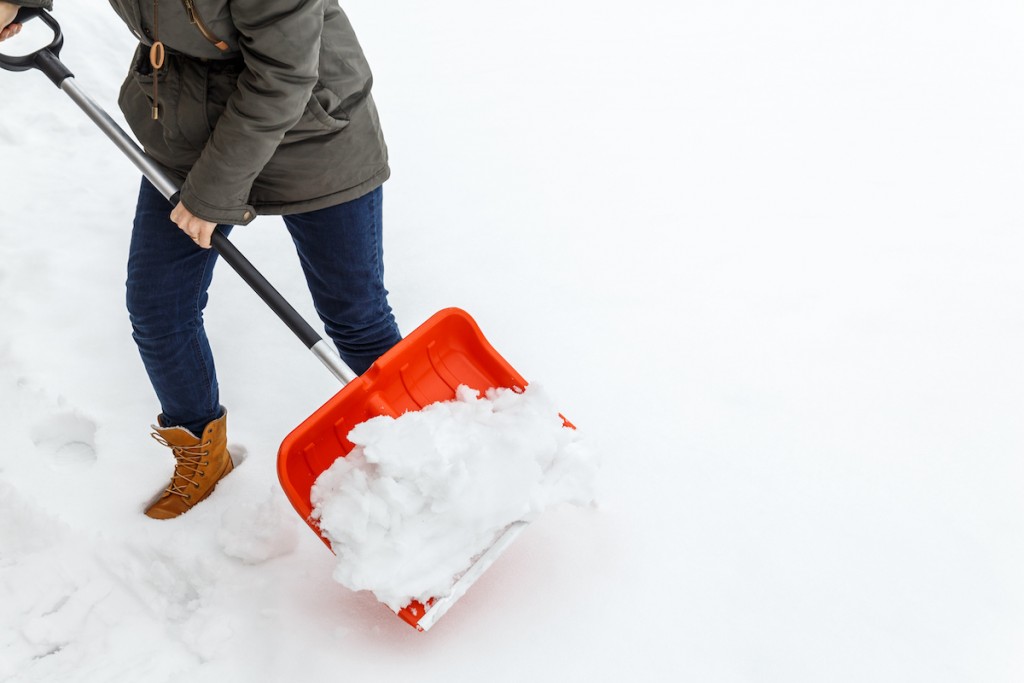 Woman With Shovel Cleaning Winter Snow.