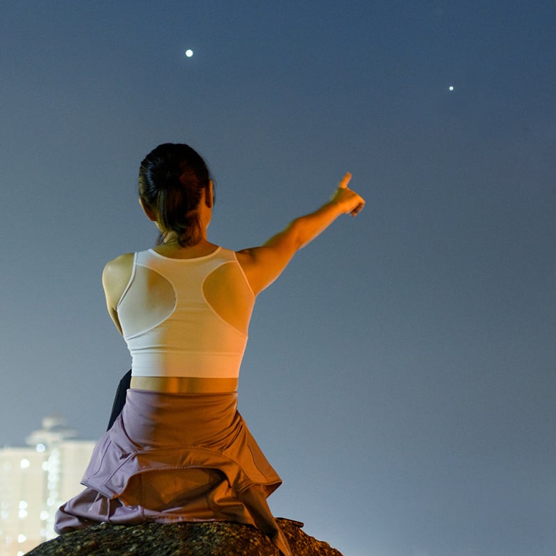 Woman With Arms Raised Pointing At The Moon
